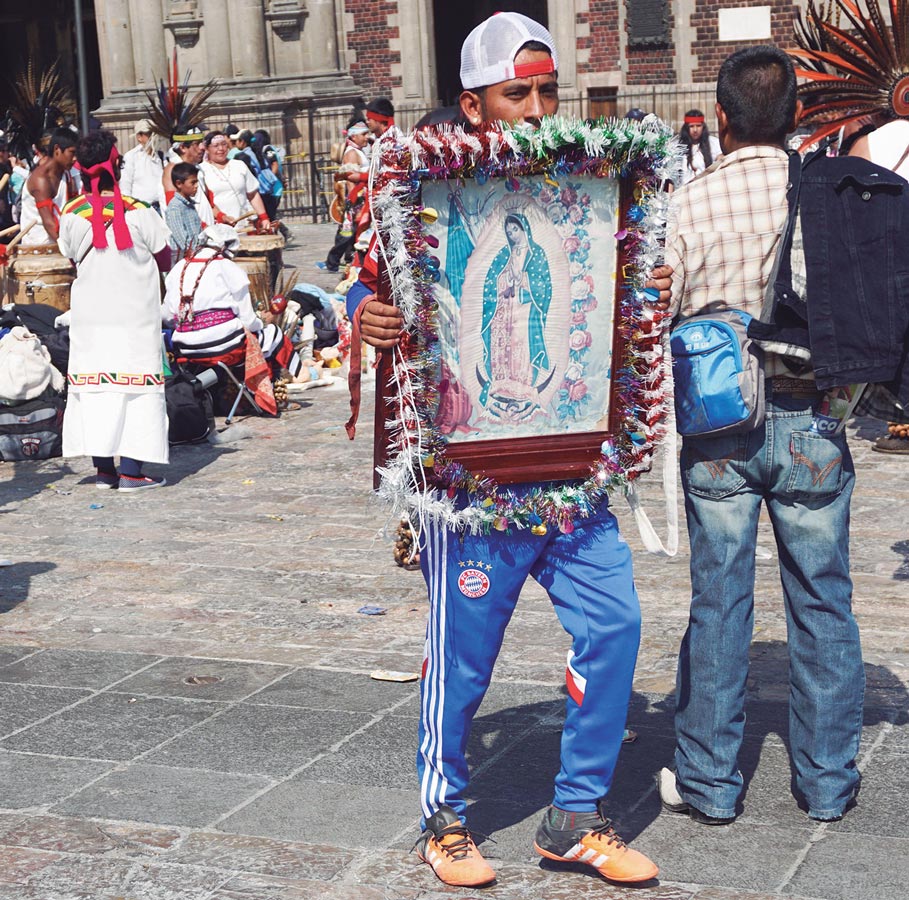 Hombre sostiene cuadro de la virgen de Guadalupe frente a la Basílica del Tepeyac, en la Ciudad de México. Fotografía de Katie Bordner, 12 de diciembre de 2016